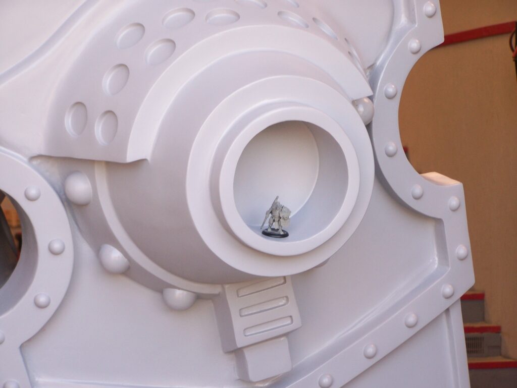 Mini Man of War figurine displayed within a larger scaled statue of the same figure.